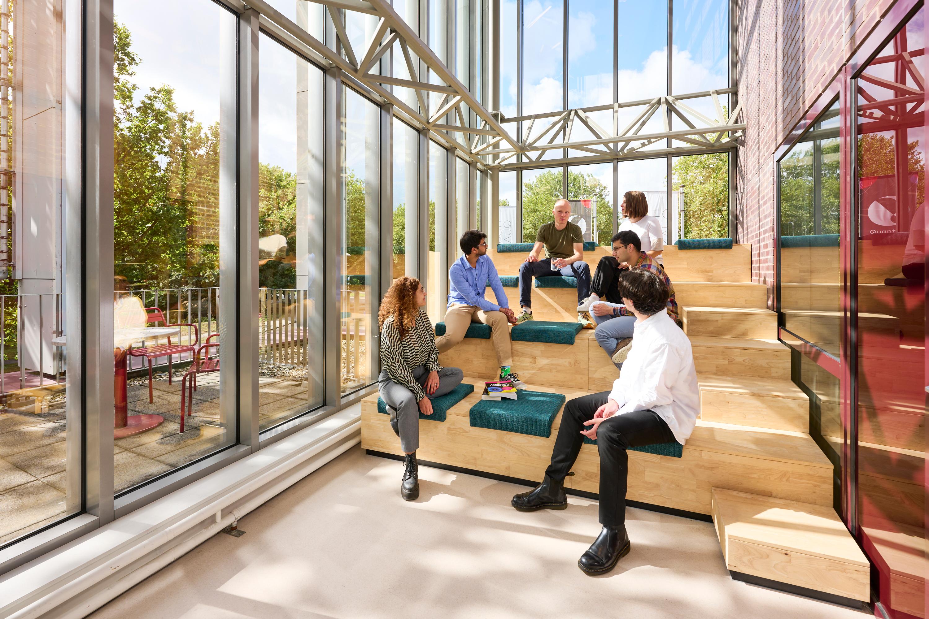 People sat on a sunny bench within the House of Quantum office